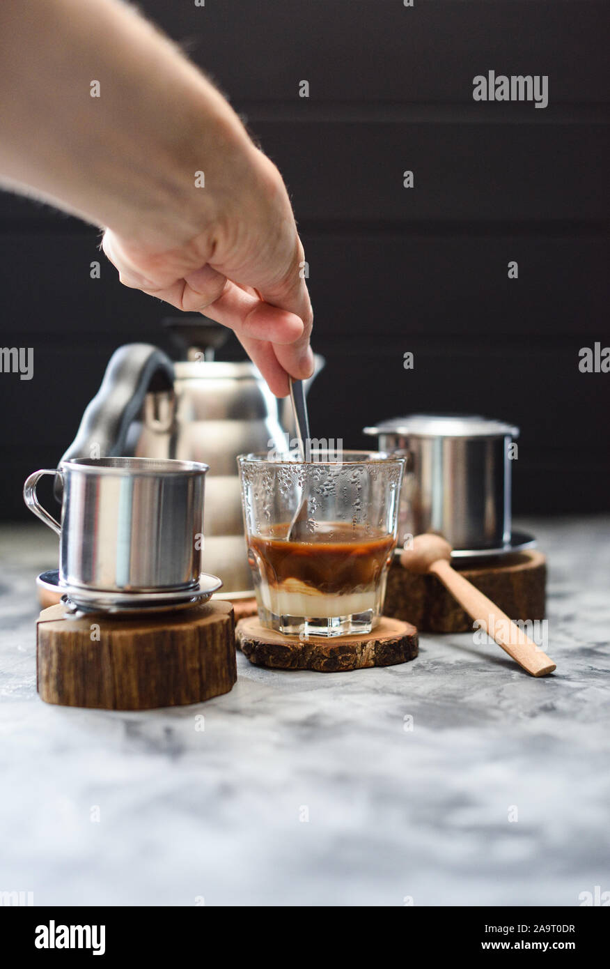 Hacer café por goteo en phin estilo vietnamita. La mano agitando el café y  leche condensada sobre fondo oscuro espacio de copia Fotografía de stock -  Alamy