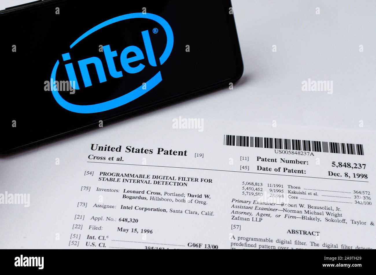 Logotipo de Intel en el smartphone y su auténtica patente sobre uno de sus invenciones relacionadas con filtros digitales. Foto de stock