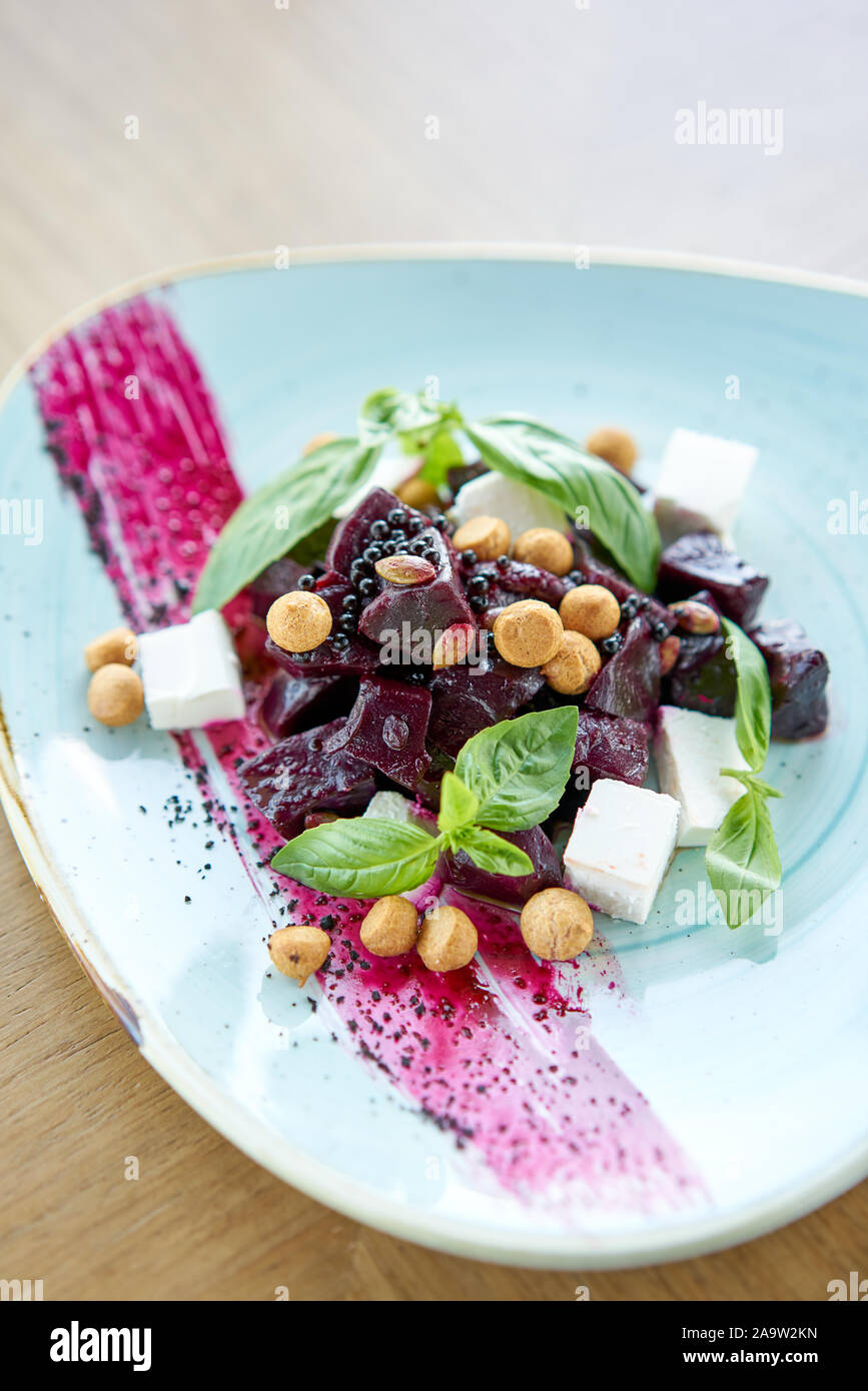Dieta saludable comida. El italiano con ensalada de remolacha, albahaca y queso feta, con aceite y pequeños profiteroles. Foto de stock