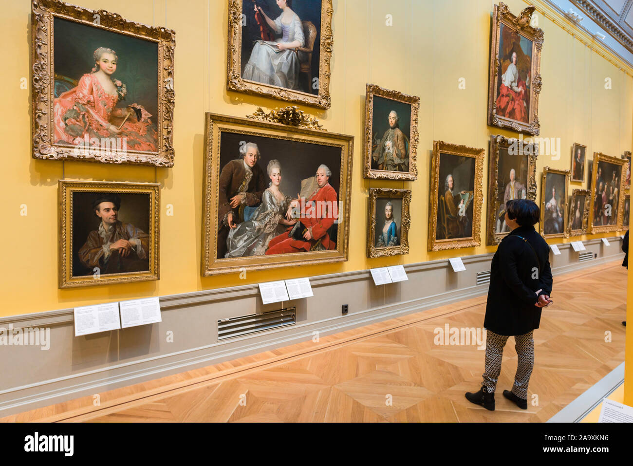 Nationalmuseum de Estocolmo, vista trasera de una mujer mirando los retratos de la nobleza del siglo XVIII en el interior del Museo Nacional de Arte, el centro de Estocolmo. Foto de stock