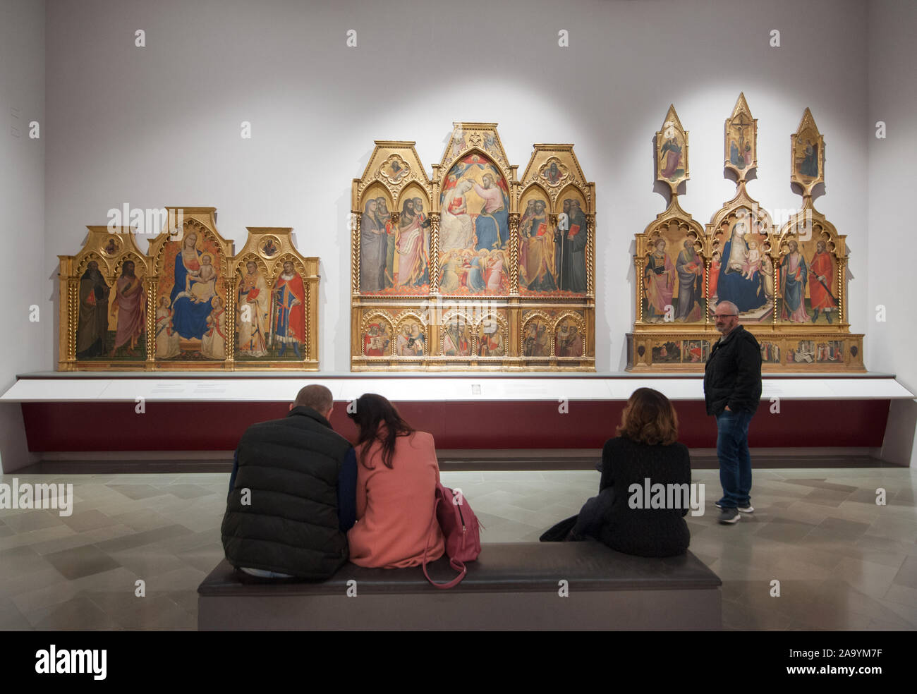 Florencia, Italia - 2019, 10 de noviembre: Pinturas en una sala de la galería de la Accademia. Los visitantes admiran algunas famosas pinturas religiosas. Foto de stock