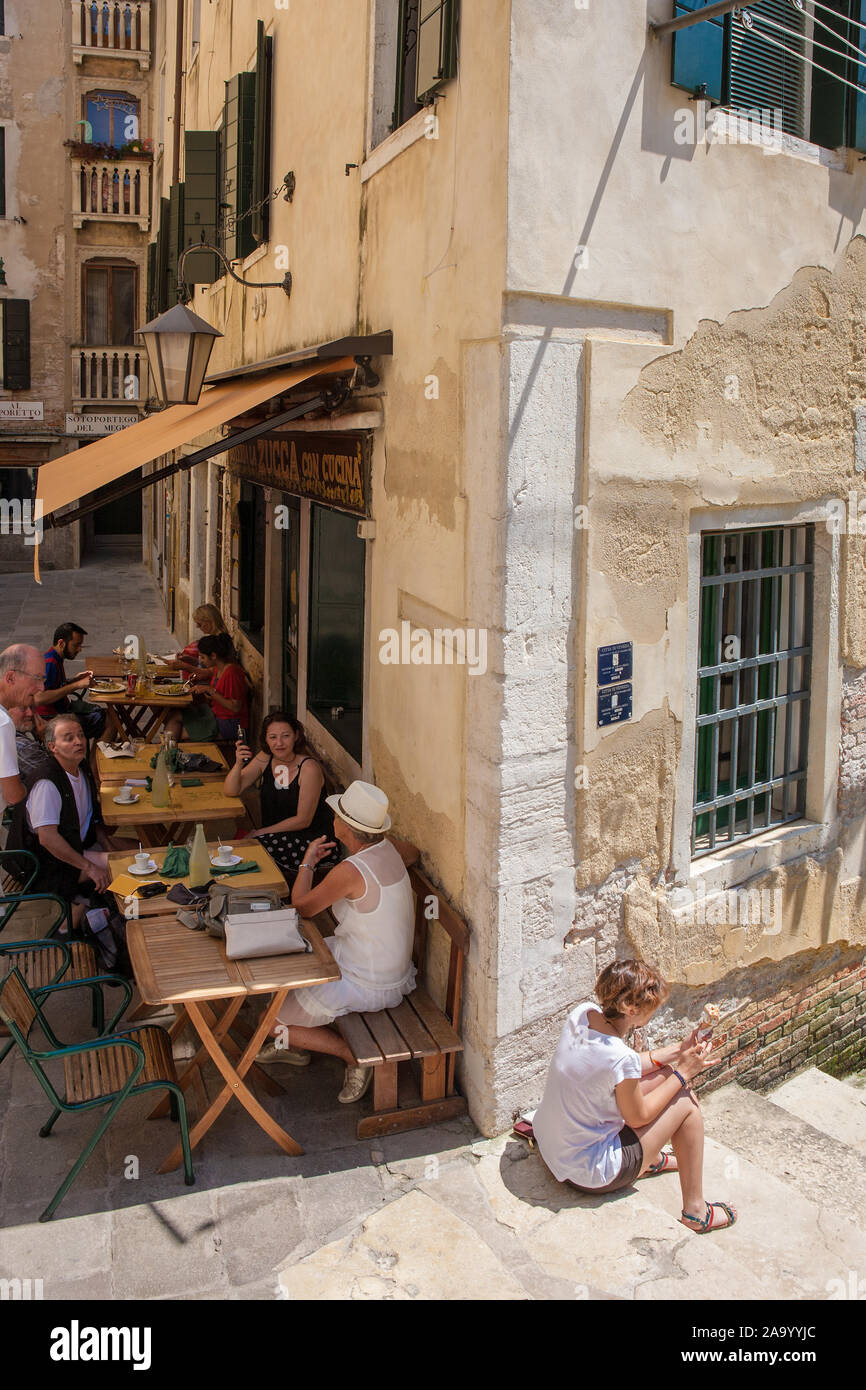 Almuerzo al aire libre en un pequeño y encantador restaurante por el Ponte del Megio en ramo del Megio llamado Osteria La Zucca, Santa Croce, Venecia, Italia Foto de stock