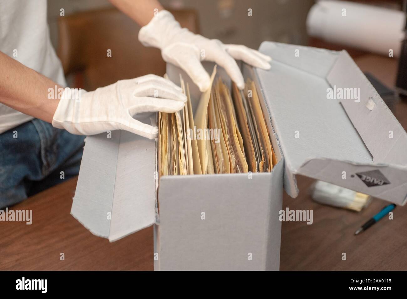 Un investigador de archivado con guante blanco mira a través de una caja de material libre de ácido de fotografías, 2 de febrero de 2009. Desde el Homewood fotografías. () Foto de stock