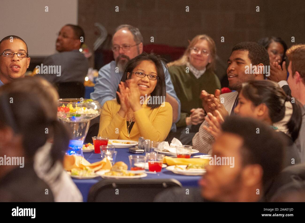 Plano medio de gente sentada en las mesas y las palmas, durante un mes de Historia Negra Dunbar-Baldwin cabaret presentado por la compañía de teatro-Hughes (DAP), de la Universidad Johns Hopkins, Baltimore, Maryland, 20 de febrero de 2009. Desde el Homewood Fotografías. () Foto de stock