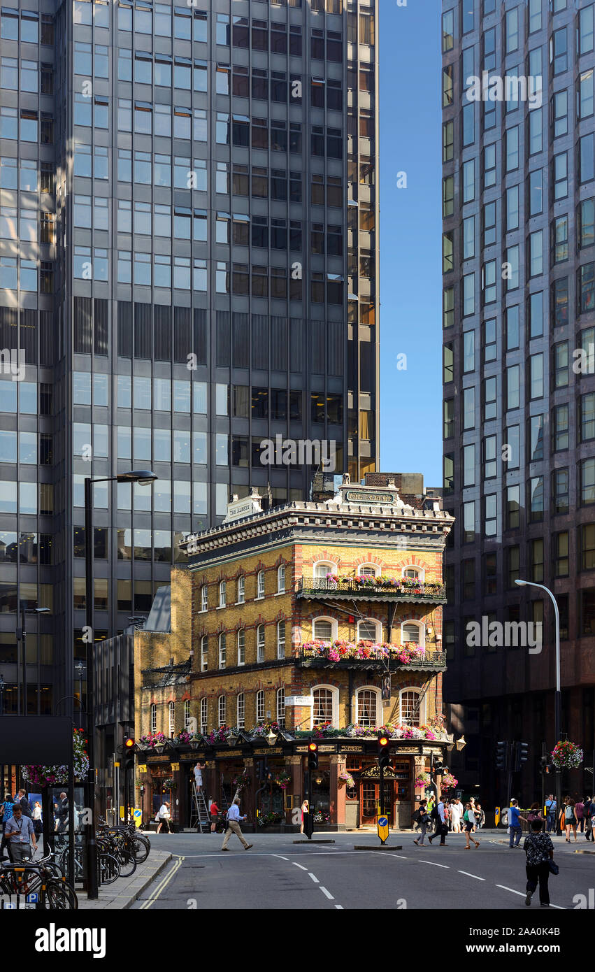 Pub de ladrillo amarillo tradicional británico entre dos modernos edificios de oficinas en el centro de Londres Foto de stock