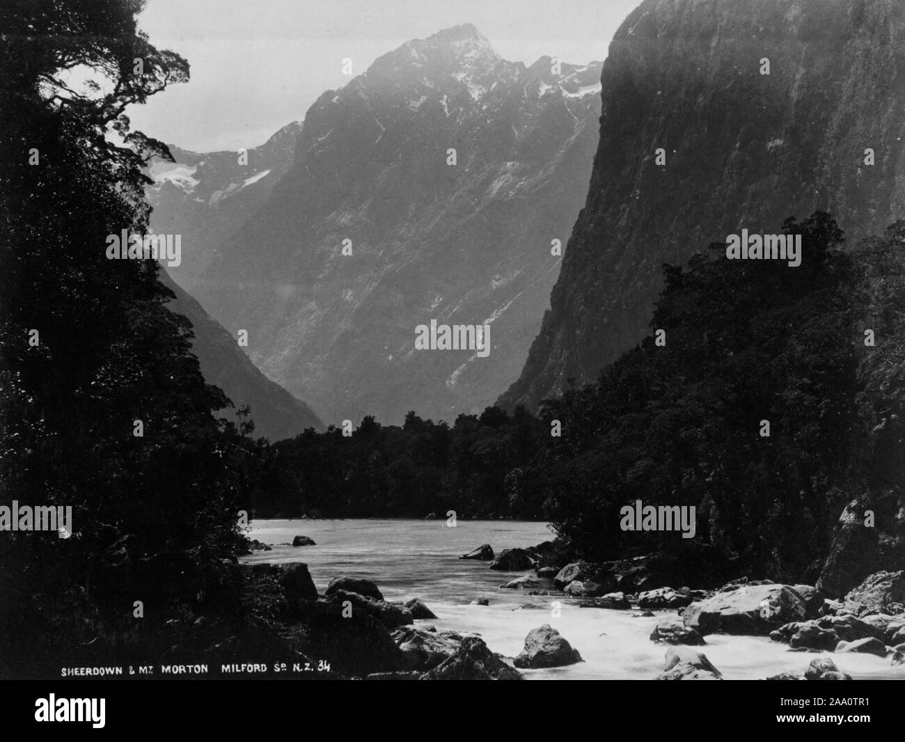 Fotografía de paisaje en blanco y negro de Milford Sound y Sheerdown pico en el Parque Nacional Fiordland, en la Isla del Sur, Nueva Zelanda, por el fotógrafo Frank Coxhead, 1885. Desde la Biblioteca Pública de Nueva York. () Foto de stock