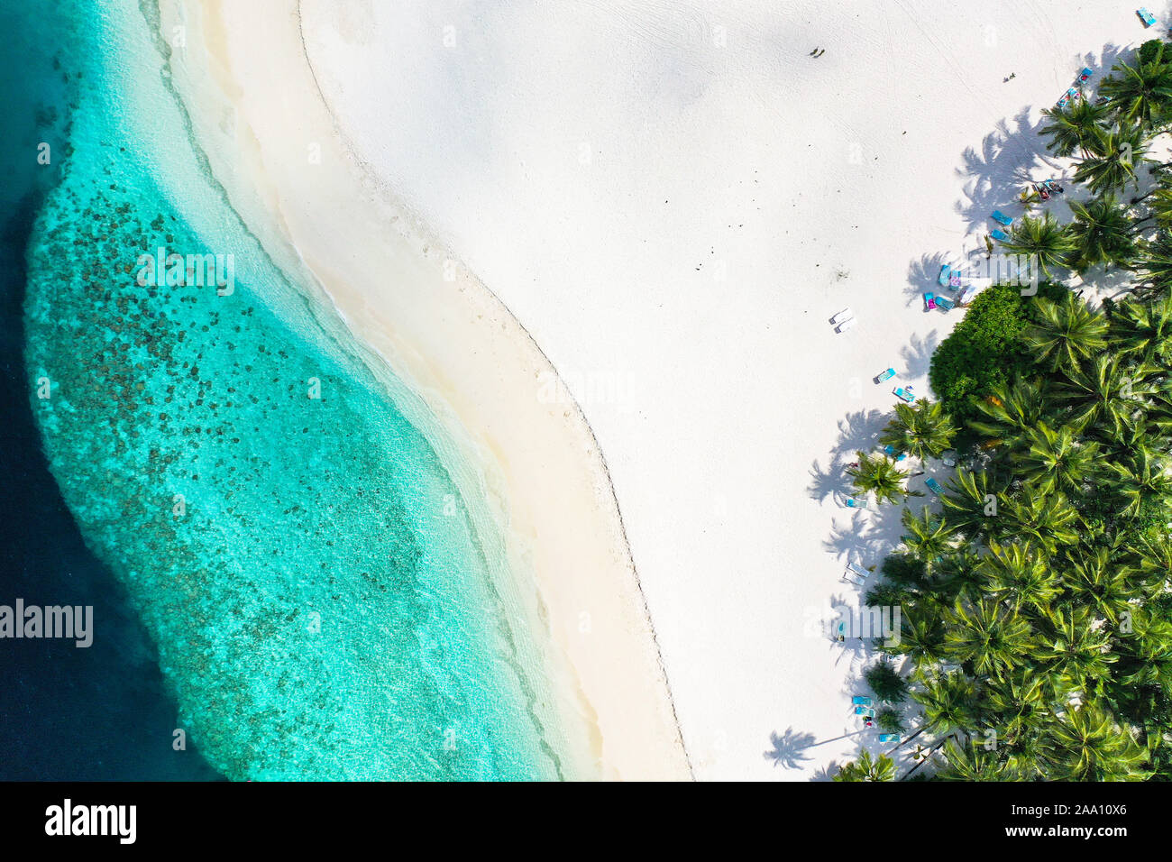 Vista superior de antena con zumbido de una exótica isla tropical paradisíaca con aguas cristalinas de color turquesa y playas de arena blanca pura Foto de stock