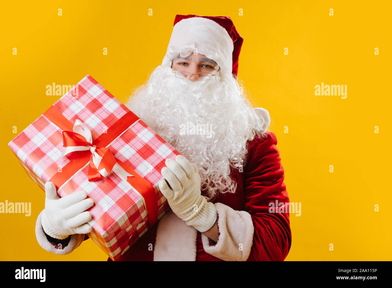 Retrato de Santa closeup mirando la cámara, sosteniendo un gran regalo Foto de stock