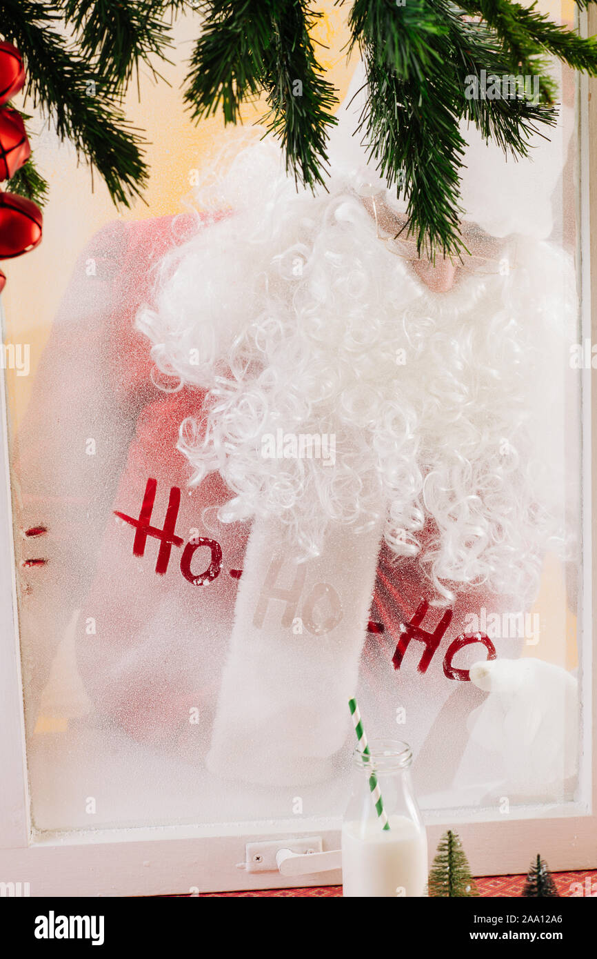 Santa está escribiendo un mensaje en una ventana congelada. Ho Ho Ho. Feliz Navidad. Foto de stock