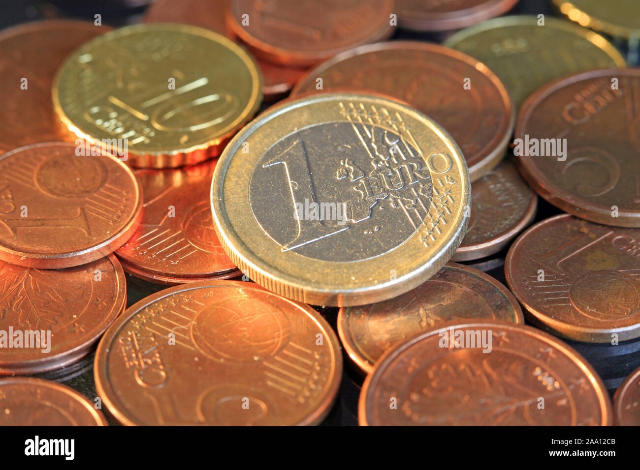Euro Münzen. Ein Euro liegt auf einem Haufen Kleingeld / monedas de euro. Un euro moneda es lieing hasta un clúster de pequeñas monedas Foto de stock