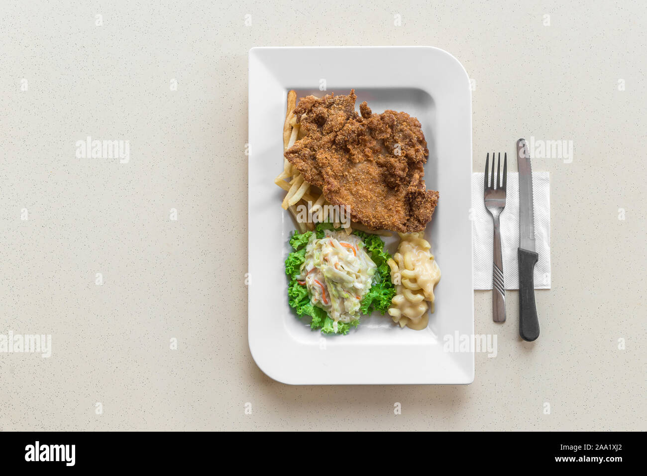 Las migas pollo chuleta con Mac y queso coleslaw en la parte superior