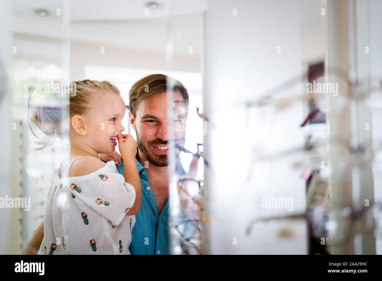 La atención de la salud, visión y concepto de la visión. Little Girl elegir  gafas con padre en tienda óptica Fotografía de stock - Alamy