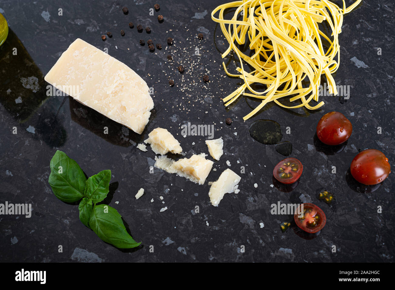 Queso parmesano, fettuccine, albahaca fresca, tomate cherry, pimienta negra y aceite de oliva Foto de stock