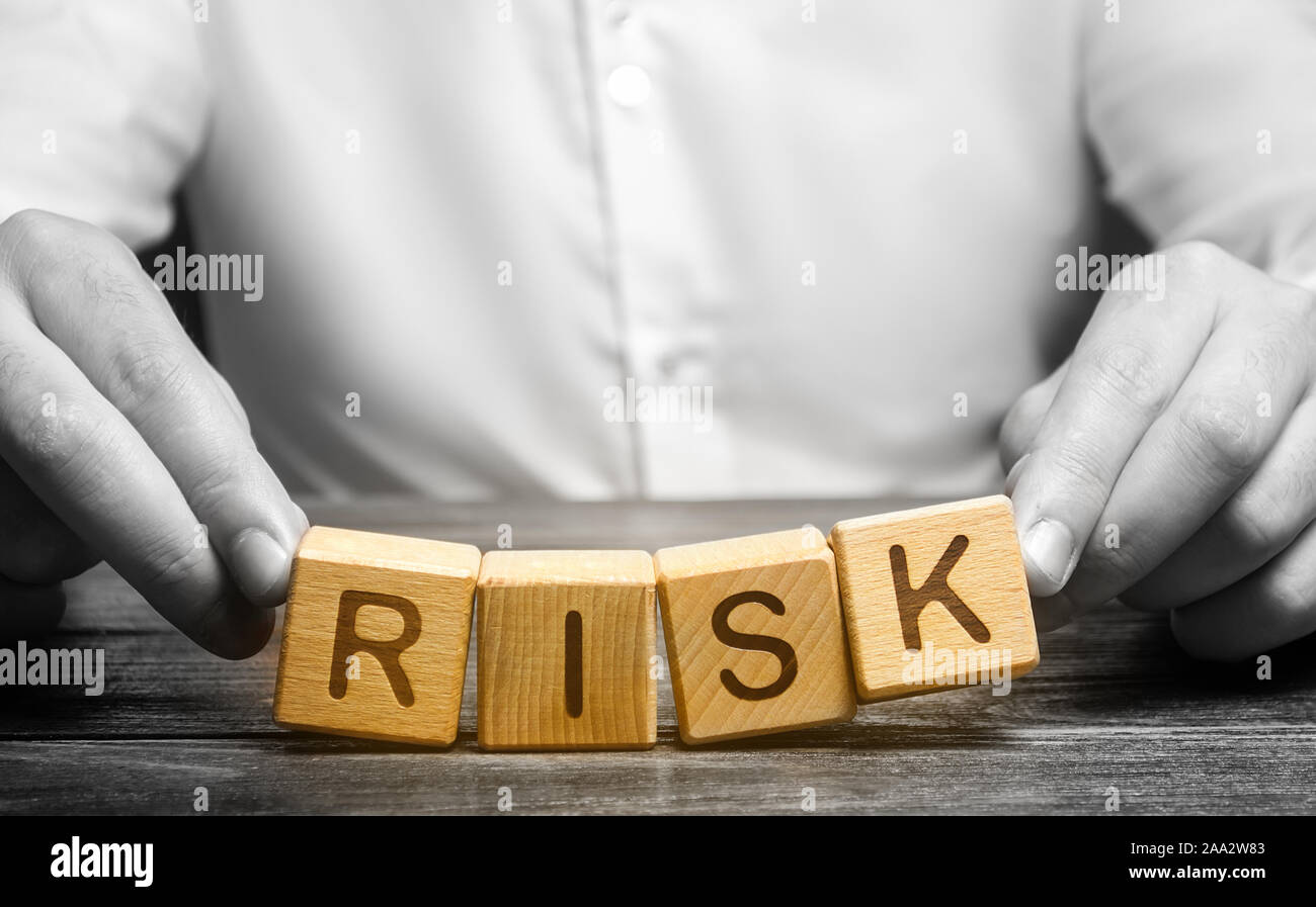 El hombre descuidadamente plantea la palabra riesgo. La prudencia y previsión de posibles problemas y perturbaciones. Planificación y estrategia de acción. Analytics. Alto riesgo Foto de stock