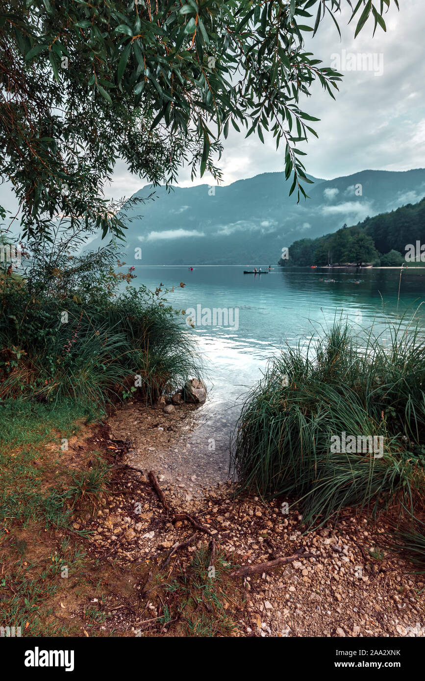 Nublado por la tarde en el lago de Bohinj, Eslovenia. La gente disfruta de las actividades del deporte de agua al aire libre en condiciones de mal tiempo Foto de stock