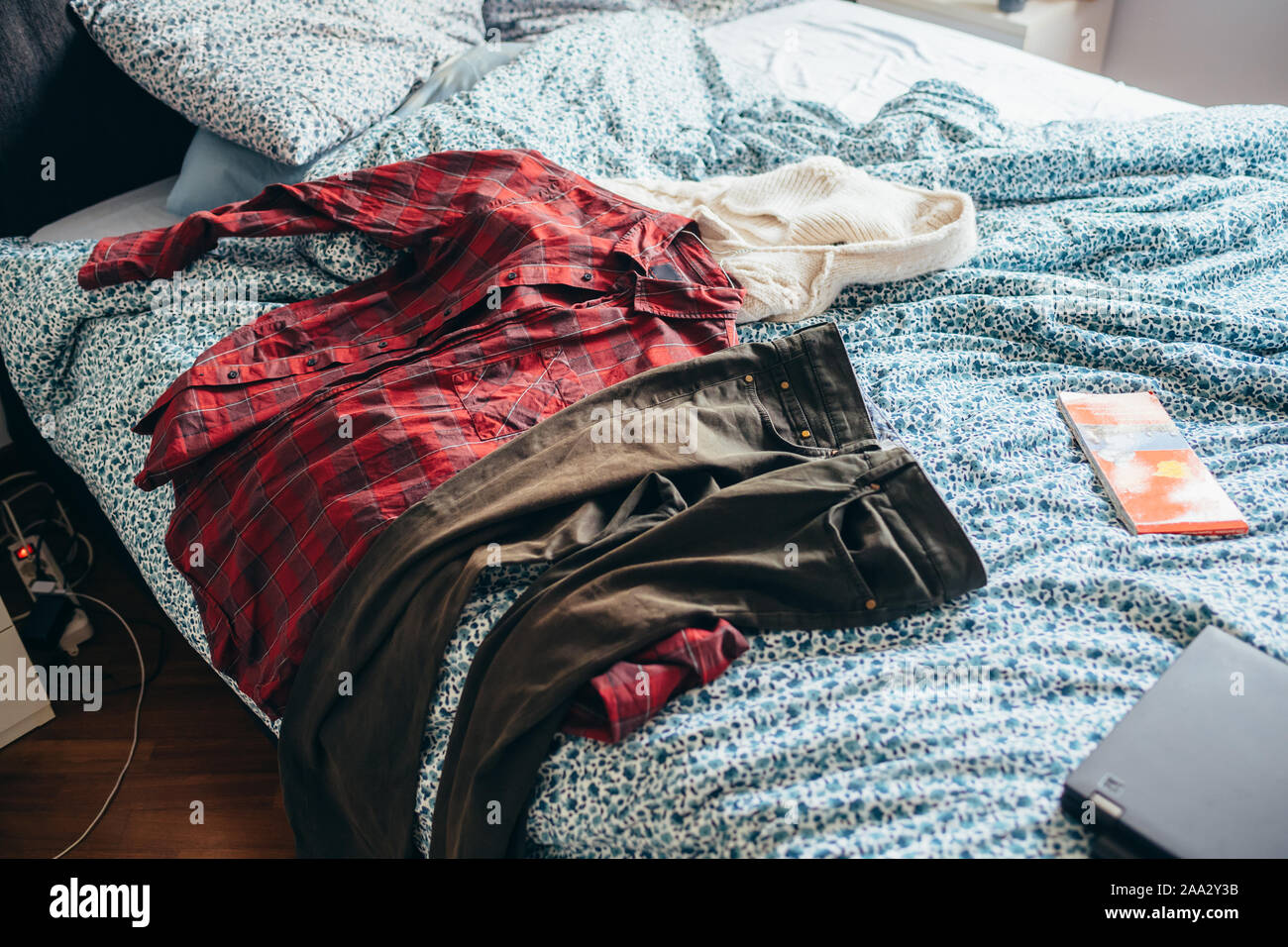 Habitación con dispersión de ropa sucia en la cama Fotografía de stock -  Alamy