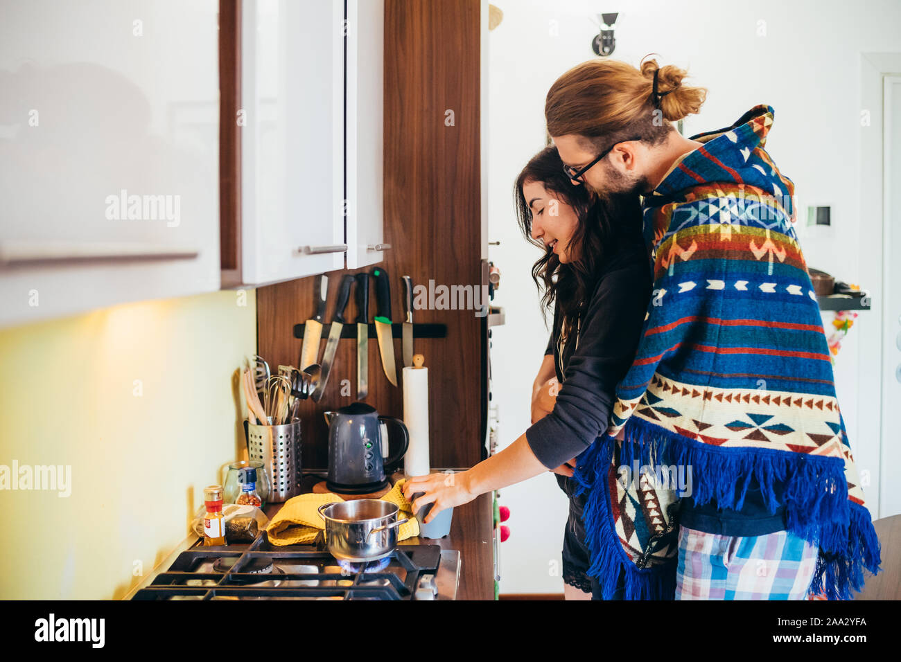 Afectuosa pareja joven cocinar la comida en la cocina de casa - Romántico, compañerismo, amor, concepto Foto de stock