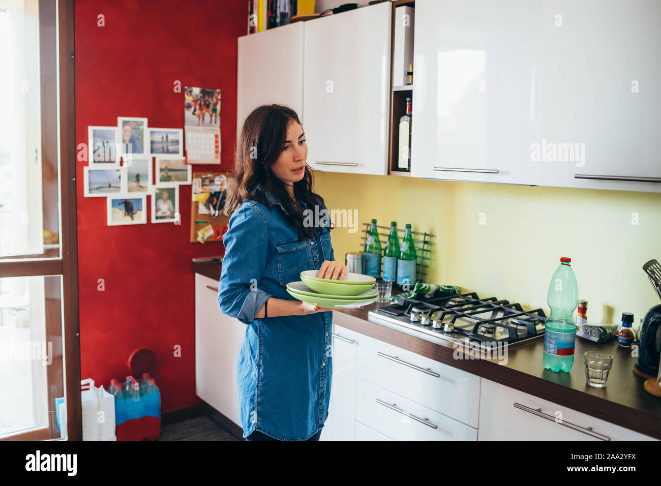 Mujer joven cocinar la comida en la cocina de casa - Preparación, compañerismo, trabajo en equipo concepto Foto de stock