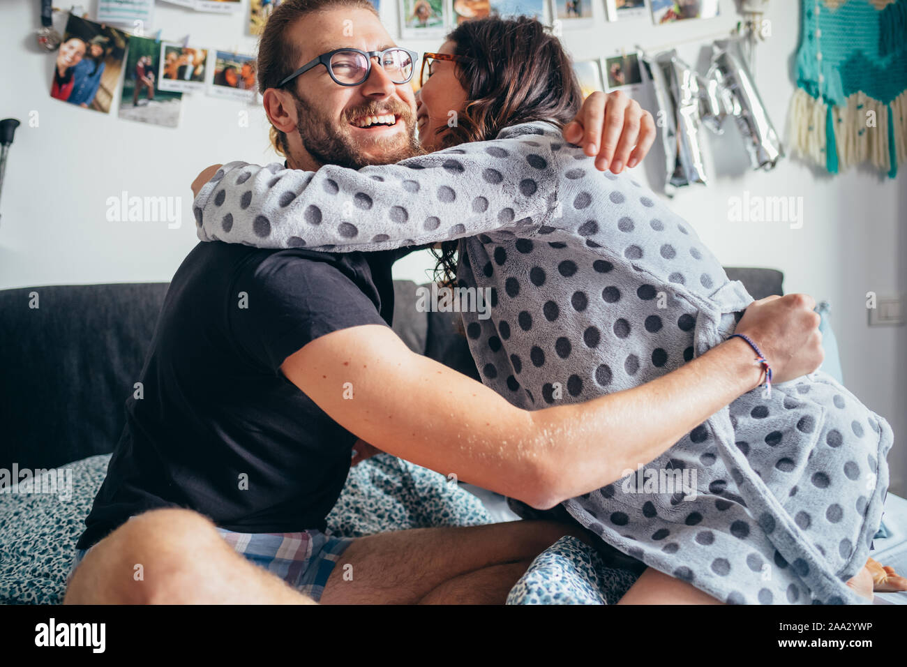 Hermosa joven feliz pareja acostada en la cama abrazando a celebrar, celebrar, una buena noticia, el concepto de la felicidad Foto de stock