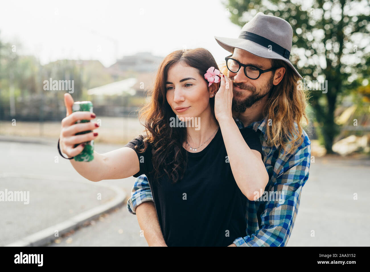 Hermosa joven pareja feliz caminar teniendo selfie exterior utilizando smartphones - tecnología, screentime, freetime concepto Foto de stock