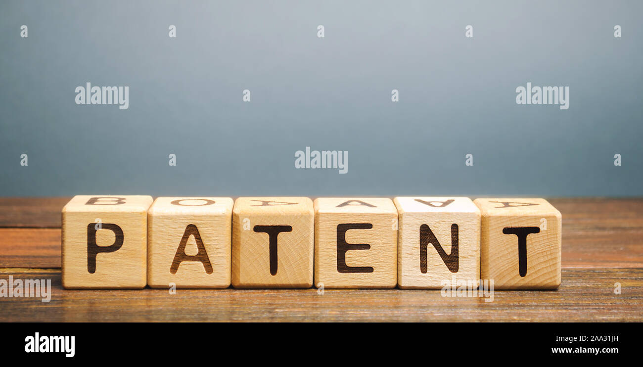 Bloques de madera con la palabra patente. Forma de propiedad intelectual. El documento que acredite el derecho de un inventor a su invención. Foto de stock