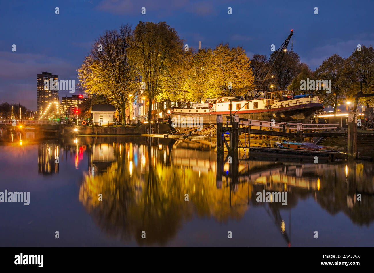 Rotterdam, Países Bajos, 13 de noviembre de 2019: el antiguo astillero y árboles en colores de otoño reflejo en el espejo de agua el antiguo puerto en el b Foto de stock