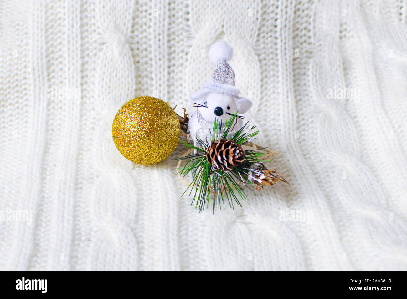 Cute little rata, ratón con bola de Navidad está sentado