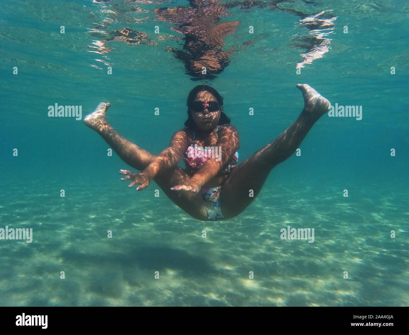 Chica jugando bajo el agua, en el mar, Puglia, Italia Foto de stock
