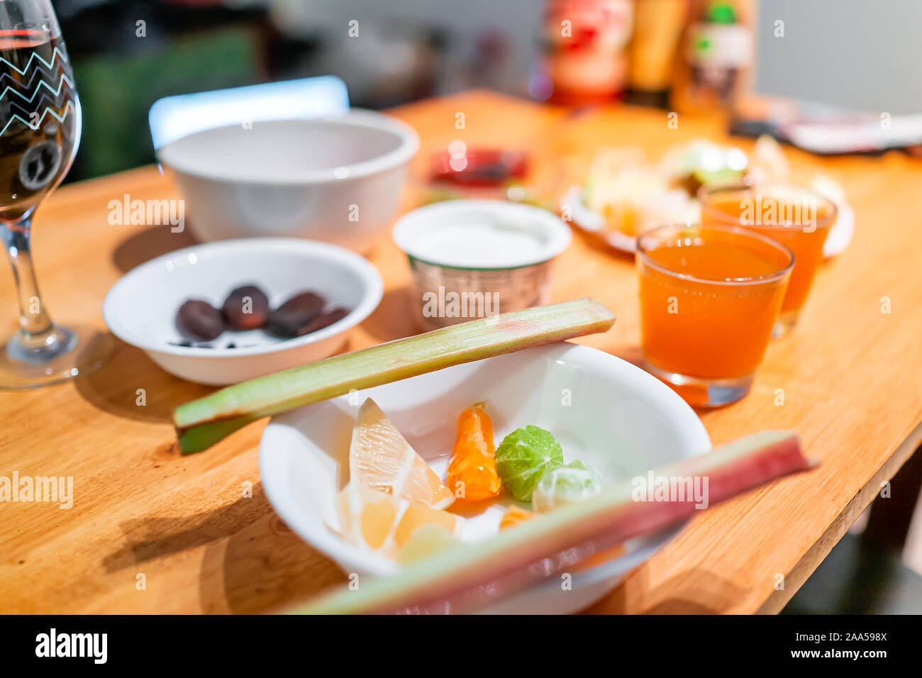 Los alimentos agrios rodajas de frutas hortalizas sirviendo en mesa de madera para desayuno con ruibarbo, limón, lima y jugo de kombucha gafas miracle berry ta Foto de stock