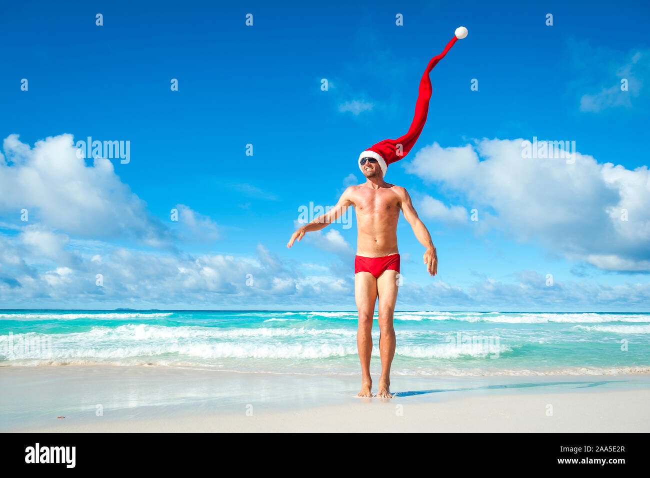 Colocar el hombre extra largo con gorro de Papá Noel para celebrar las  fiestas de navidad rojo resúmenes de natación en la orilla de una playa  tropical Fotografía de stock - Alamy