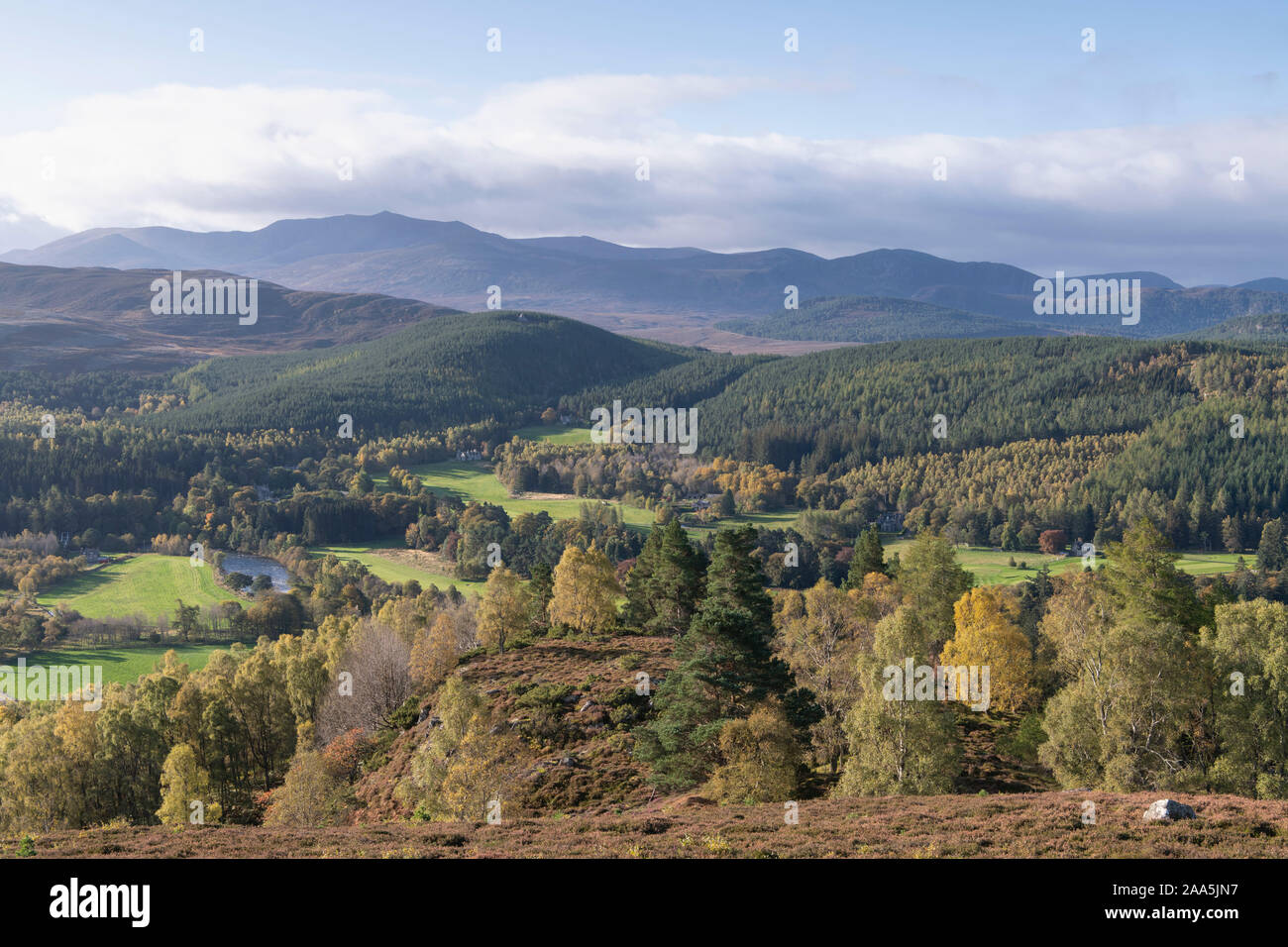 Una vista sobre el Royal Deeside hacia Lochnagar en otoño con el Príncipe Albert's Cairn visibles en la colina en la media distancia Foto de stock