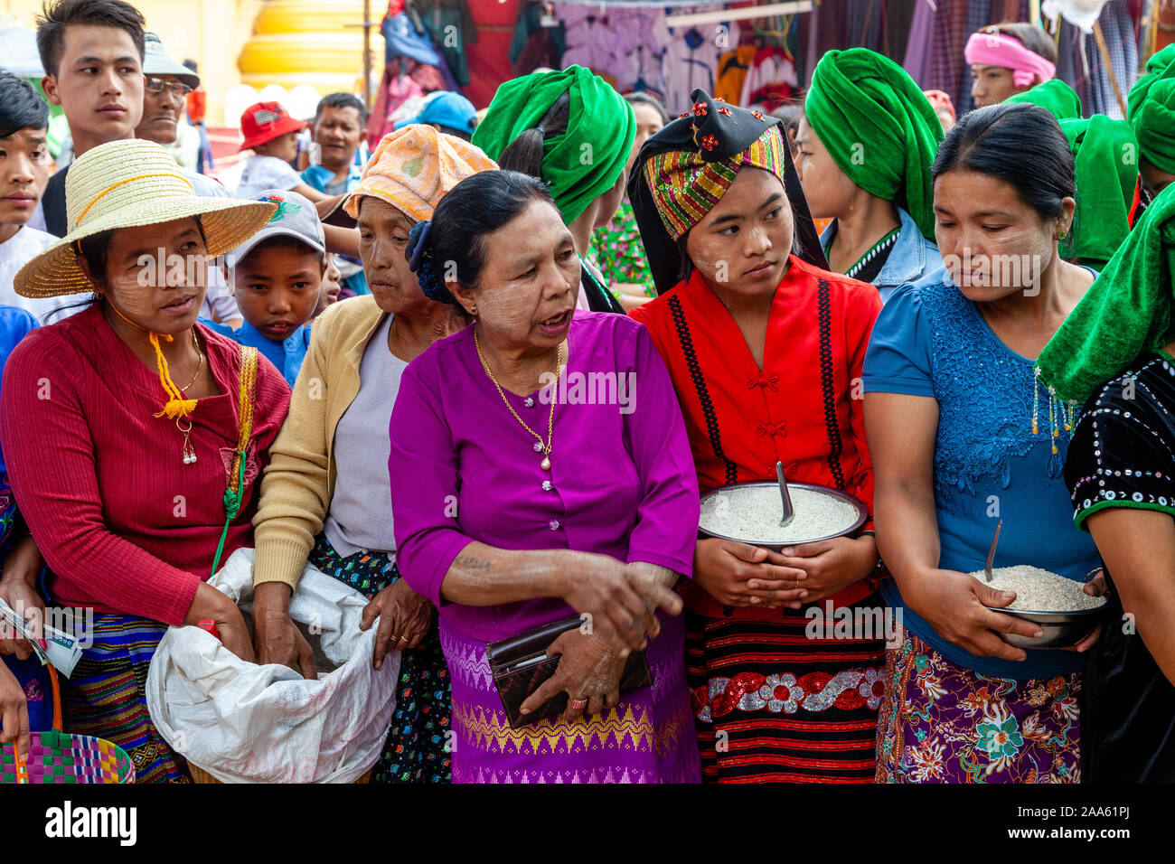Las mujeres de las minorías étnicas Esperar para dar limosna a los monjes que están tomando parte en una procesión, el Festival de la cueva de Pindaya Pindaya, Estado de Shan, Myanmar Foto de stock