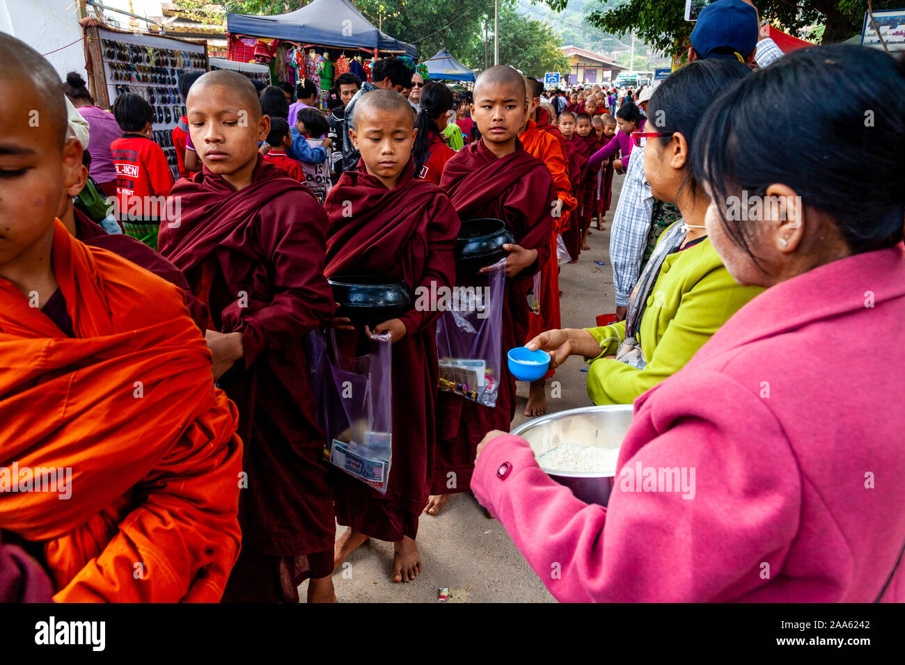 Los monjes novicios camine por la calle principal en Pindaya pidiendo limosna durante el Festival, la cueva de Pindaya Pindaya, Estado de Shan, en Myanmar. Foto de stock