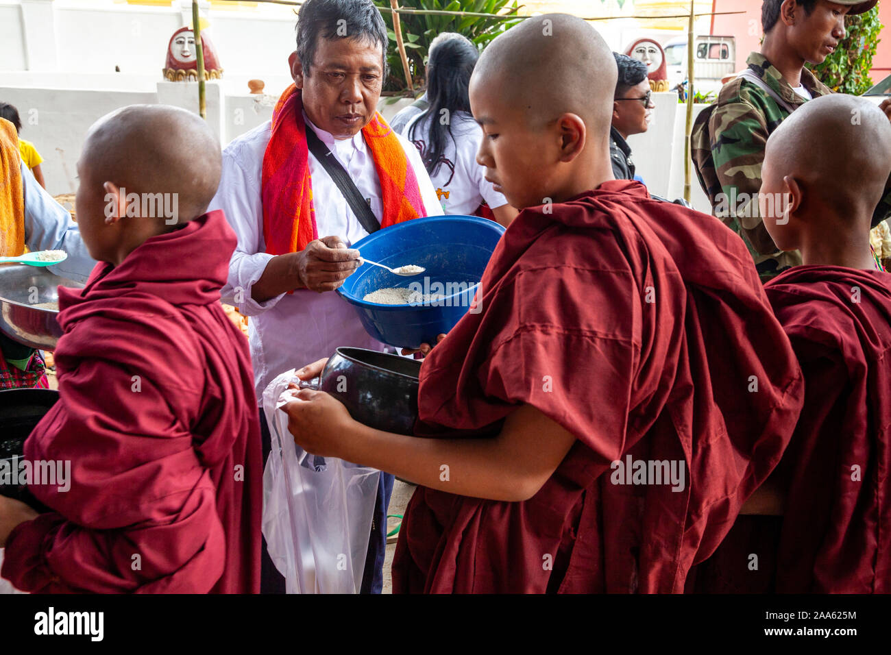Los monjes novicios camine por la calle principal en Pindaya pidiendo limosna durante el Festival, la cueva de Pindaya Pindaya, Estado de Shan, en Myanmar. Foto de stock