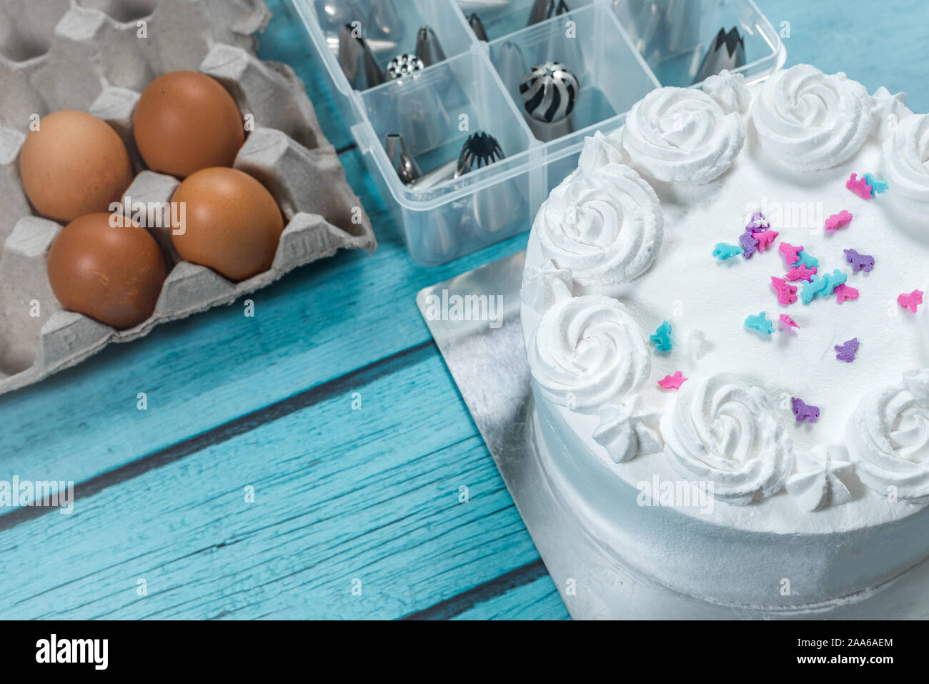 Glaseado de tartas, pasteles hornear haciendo utensilios y accesorios de cocina huevos crudos en la mesa Foto de stock