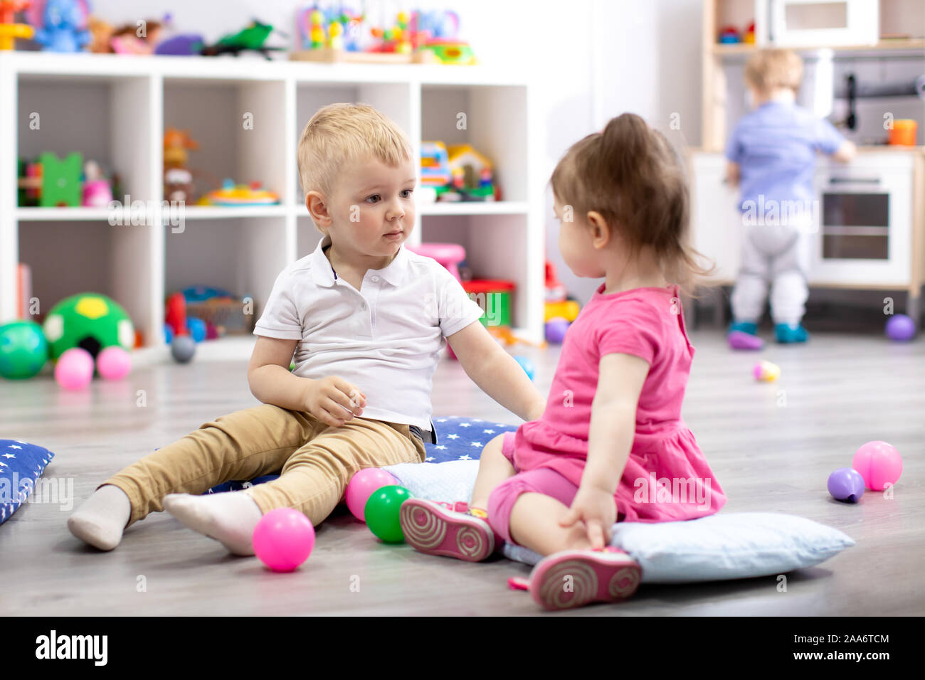 Los niños juegan con juguetes coloridos. Niño niña y niño pequeño niño en el kindergarten. Los niños juegan en la guardería o al preescolar. Foto de stock