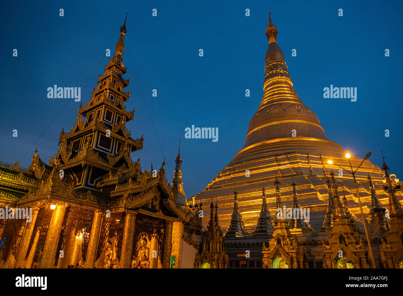 Shwedagon Pagoda y sus numerosas capillas bañados en pan de oro en Yangon, Myanmar (Birmania) con el trasfondo de un oscuro cielo nocturno claro Foto de stock