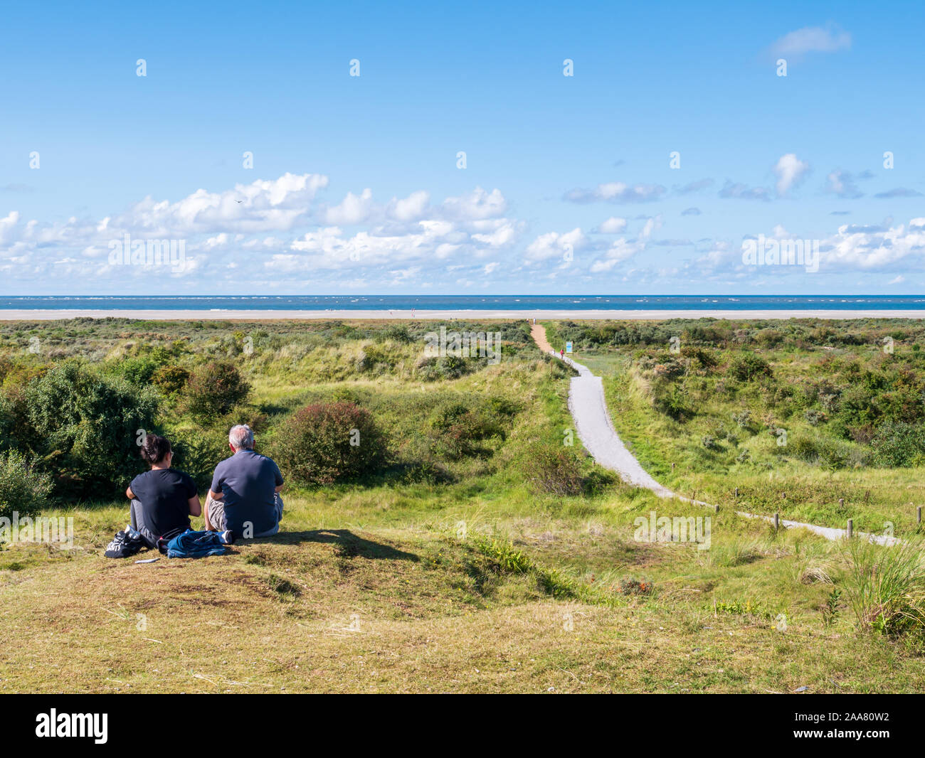 La gente descansando en las dunas y sendero hacia la playa del Mar del Norte Isla Schiermonnikoog en Frisia, Holanda Foto de stock