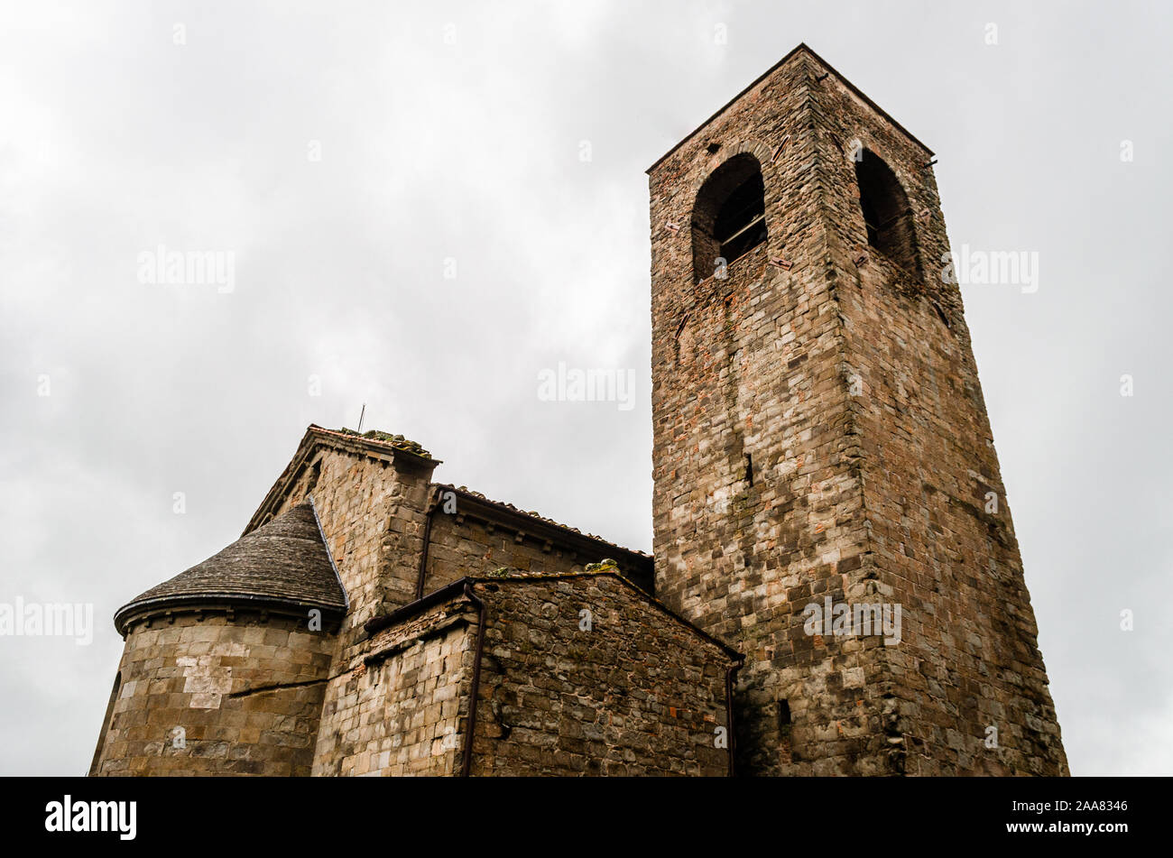 Viejo Valdibure, Pistoia, Toscana, Italia la iglesia parroquial de San Juan San Giovanni Montecuccoli un edificio de piedra con campanario contra el cielo blanco Foto de stock