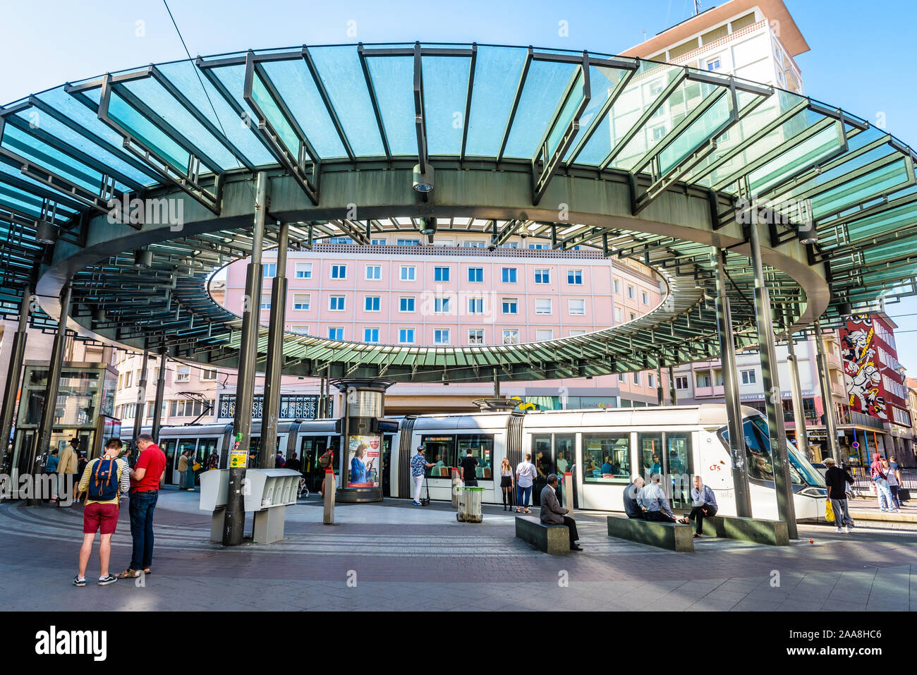 Un plataformas Citadis tranvía es estacionar en la estación Homme de Fer, la concurrida estación de la red CTS en Estrasburgo, Francia, rematada por una cúpula de vidrio Foto de stock