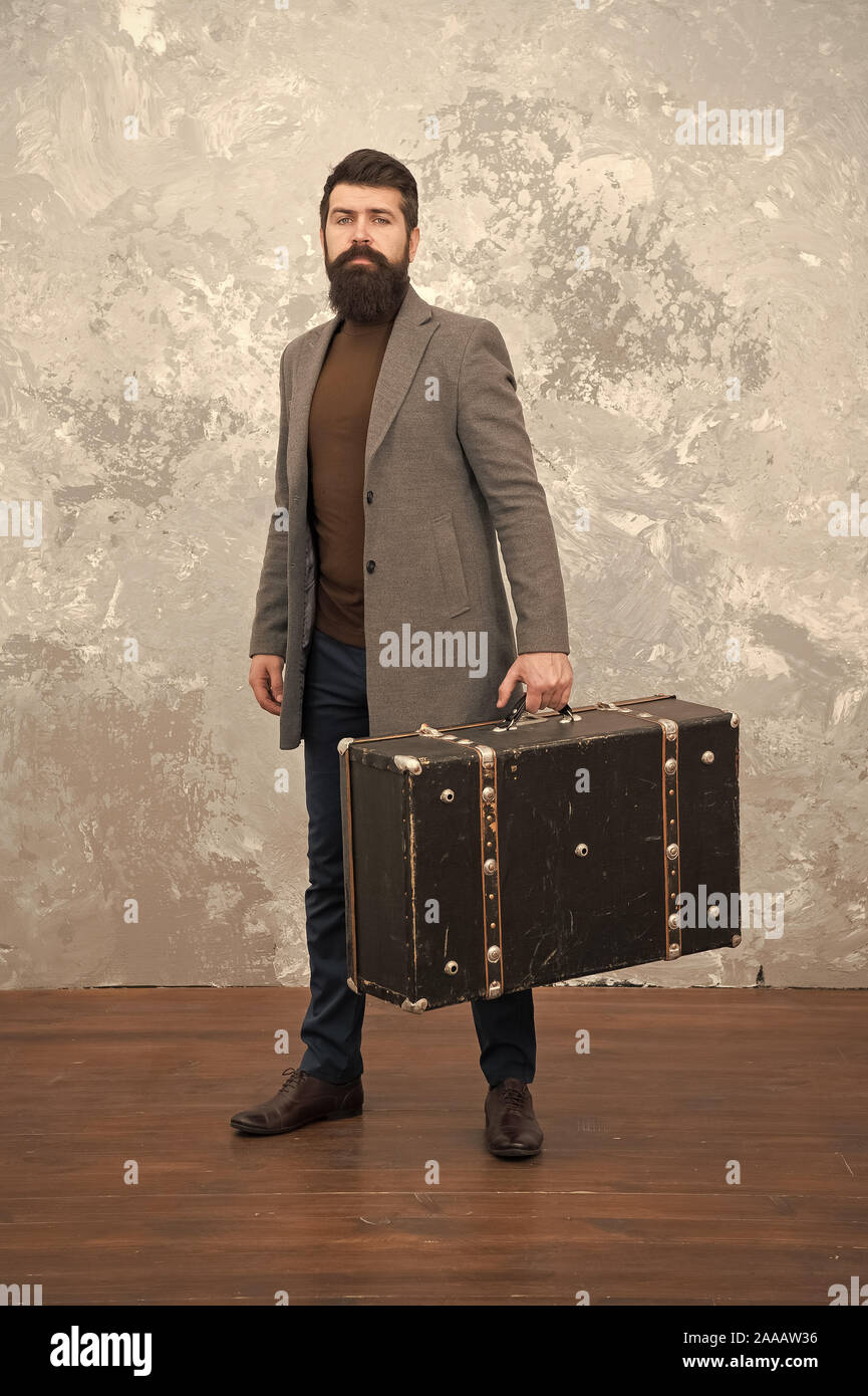 Retro y vintage. Tendencia de moda. Accesorios para las vacaciones. Mejores  bolsas de viaje para los hombres. Guy bien arreglados elegante hombre  barbado y vintage maleta. Tiempo Viajero concepto. Vintage inspirado diseño