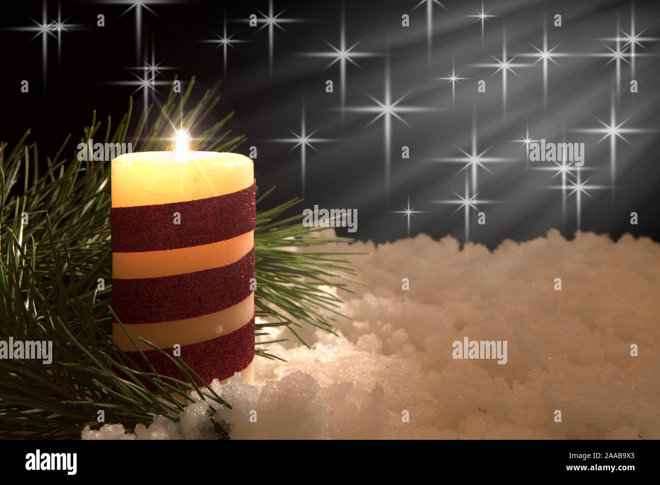 Encendido de velas blancas y cinta roja con agujas de pino con el haz de  luz en la nieve. Negro con fondo de Navidad vacaciones en el tema  Fotografía de stock -