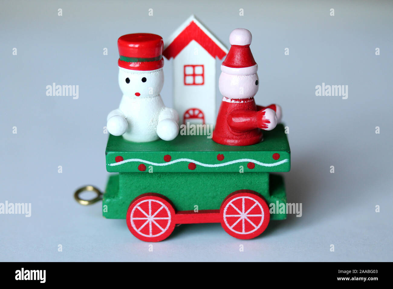 Tren de madera festiva verde coche o transporte sobre fondo blanco. Navidad  y Año nuevo juguete con figuras de muñeco de nieve, gnome y de la casa.  Tarjeta de felicitación, po Fotografía