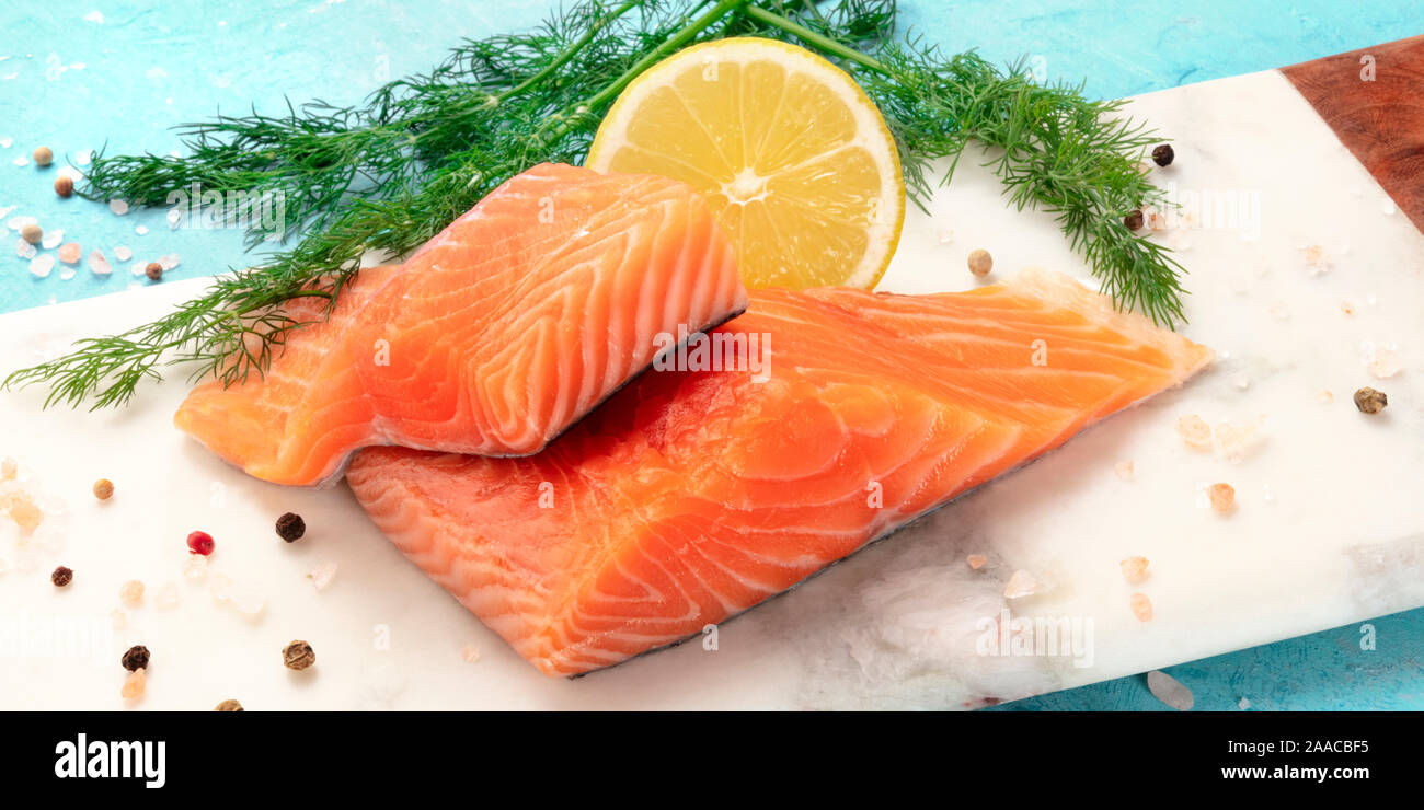 Rodajas De Salmon Con Limon Y Eneldo Cerca De La Fotografia Panoramica Con Sal Y Pimienta Cocinar Pescado Sobre Un Fondo Azul Fotografia De Stock Alamy