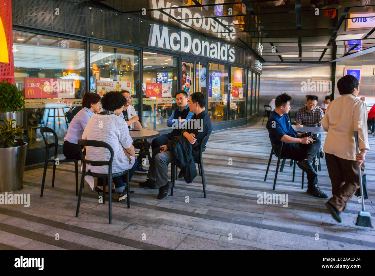 Shanghai, China, la gente fuera de las tablas, compartiendo comidas,  restaurante de comida rápida McDonald's en Zhong Hai Huan YU Hui, Centro  comercial, Zona de Xin Tian Di Fotografía de stock -