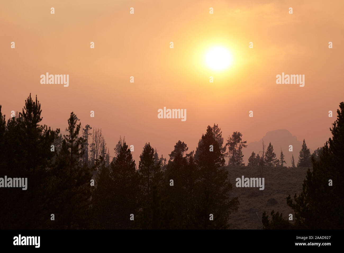 Humo de incendios silvestres mejora la puesta de sol en las montañas de diente de sierra, Idaho, EE.UU. Foto de stock