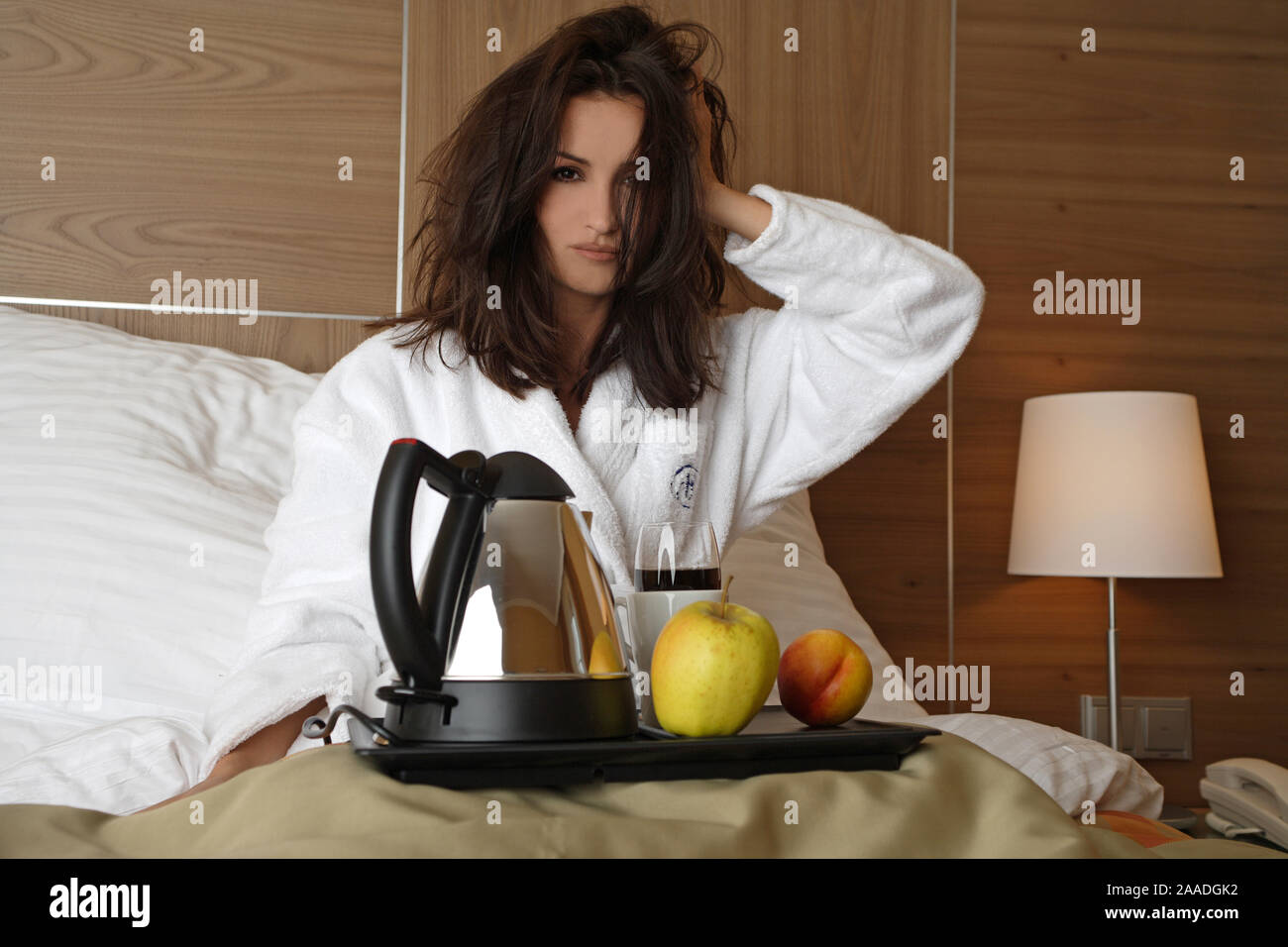 Junge Frau mit Fruehstueck muede Bett im, gaehnt, Foto de stock
