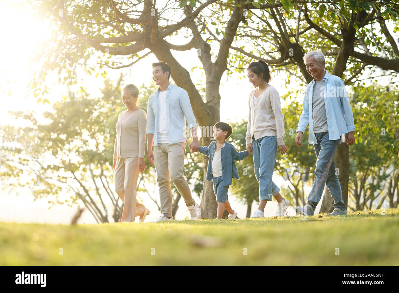 Tres generaciones de la familia de Asia feliz caminar al aire libre en el parque Foto de stock