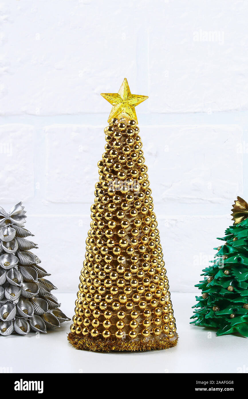 Árbol de Navidad de oro de bricolaje desde abalorios Garland. Guía sobre la  foto cómo hacer un árbol de Navidad decorativos de cartón, estrellas,  pegamento caliente y abalorios wit Fotografía de stock -