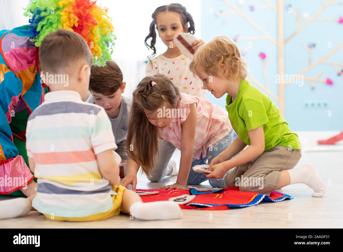 Payaso entretiene a los niños preescolares en los partidos de grupo Foto de stock